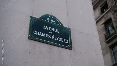Classic street sign of Avenue Champs Elysees or Elysian Fields located on a house in Paris. France. Shot with parallax effect relative to houses in the background. Illustration of shopping and