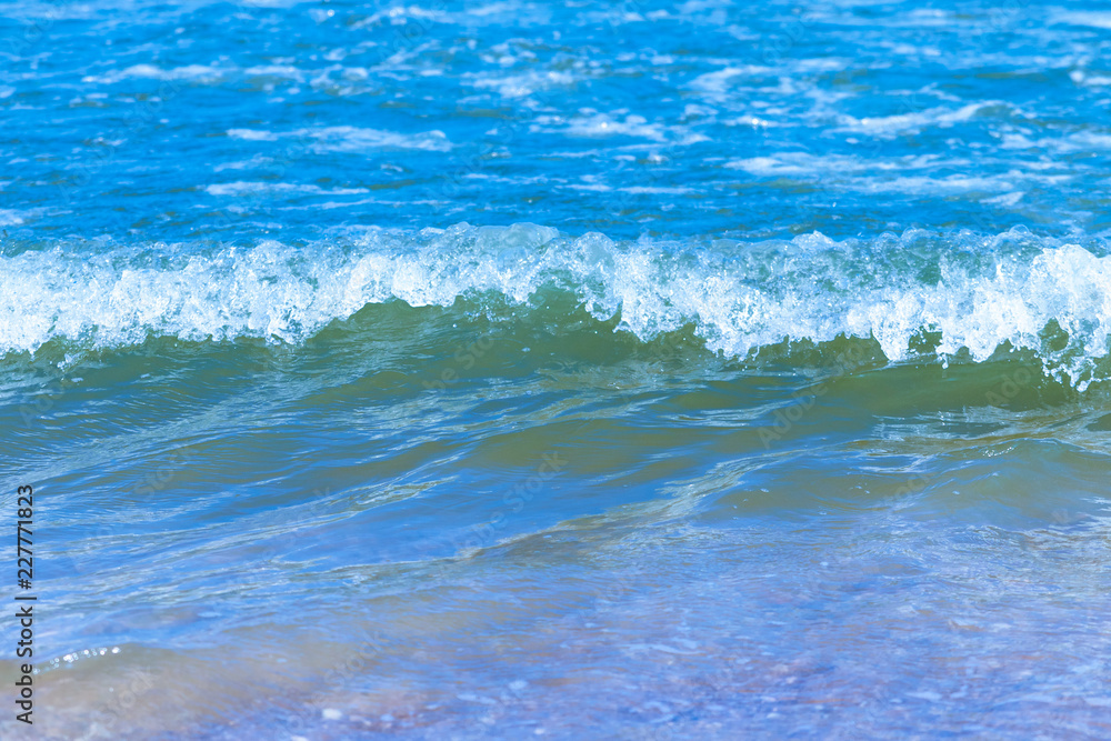 Close up view indigo sea with ripples and colorful is beautiful on the sand.