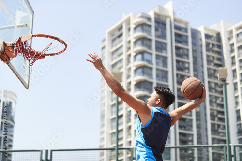 young asian adult dunking