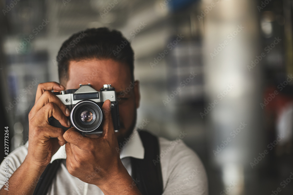 Pleasant Hindu man making professional shots while enjoying photography practice Pleasant Hindu man making professional shots while enjoying photography practice