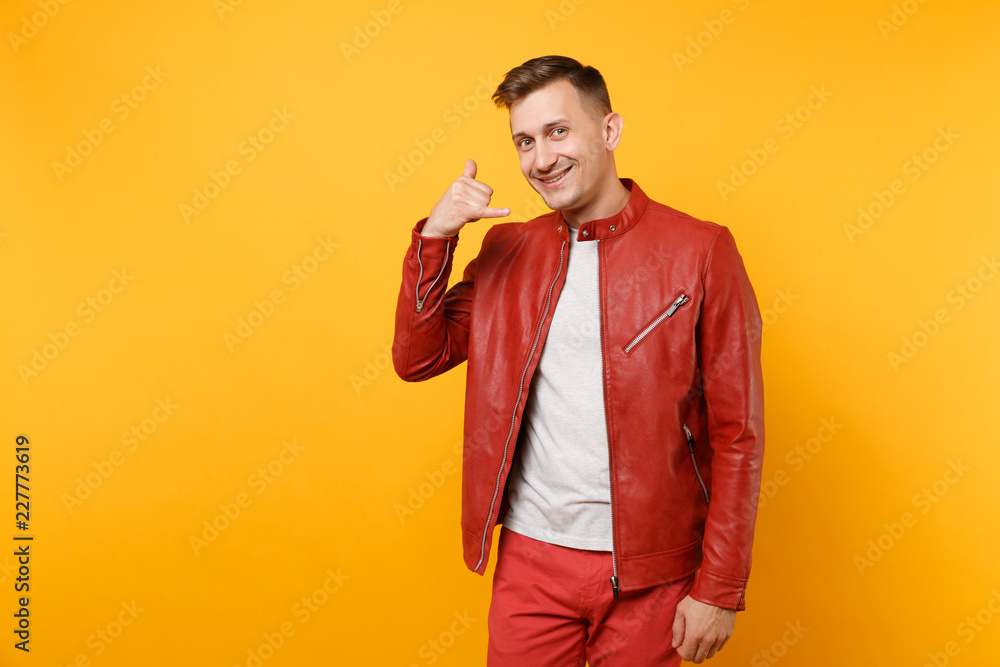 Portrait vogue smiling handsome young man 25-30 years in red leather jacket, t-shirt standing isolated on bright trending yellow background. People sincere emotions lifestyle concept. Advertising area Portrait vogue smiling handsome young man 25-30 years in red leather jacket, t-shirt standing isolated on bright trending yellow background. People sincere emotions lifestyle concept. Advertising area