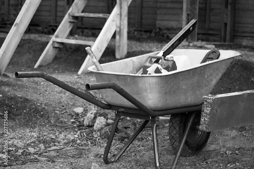 Black and white trolley with tools and canister at a construction site