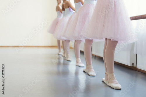 Little ballerinas standing in row and practicing ballet