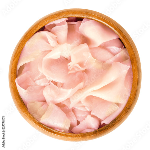 Gari, pickled ginger in wooden bowl. Sushi ginger. Japanese pickled vegetable, made from sweet, thinly sliced young ginger, marinated in sugar and vinegar. Food photo closeup from above over white.
