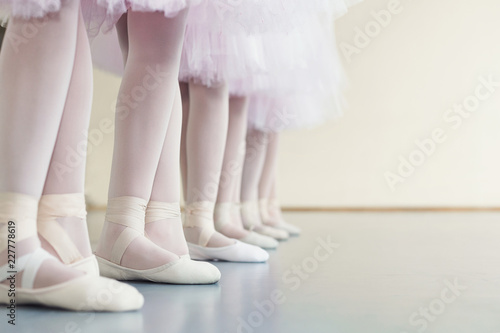 Legs of little ballerinas standing in fifth position