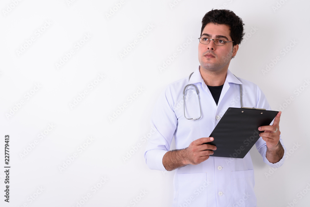 Young handsome Persian man doctor wearing eyeglasses against whi Young handsome Persian man doctor wearing eyeglasses against whi