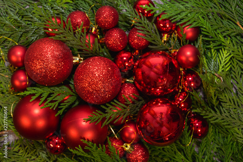 New Year's, Christmas red decorations and green coniferous branches on a gray background
