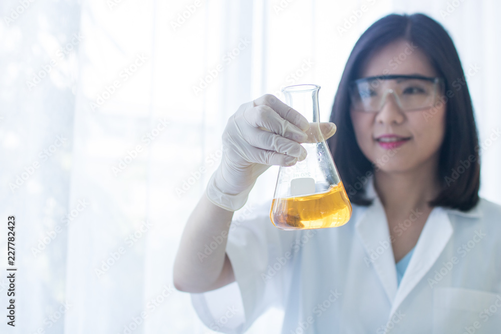 scientist woman holding test glass in lab, young researcher testing chemical reagent in laboratory scientist woman holding test glass in lab, young researcher testing chemical reagent in laboratory