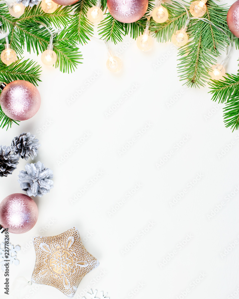 Christmas background with fir tree branches, Christmas lights, pink and beige decorations, silver ornaments Christmas background with fir tree branches, Christmas lights, pink and beige decorations, silver ornaments