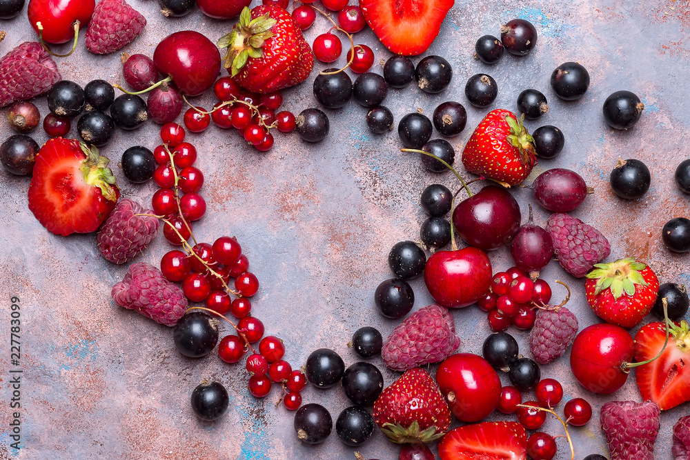 Heart shape assorted berry fruits on stone background. Flat lay Heart shape assorted berry fruits on stone background. Flat lay