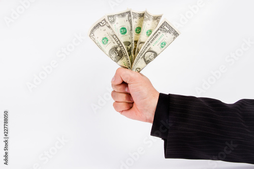 male business hand in a striped suit holds a few dollar bills.