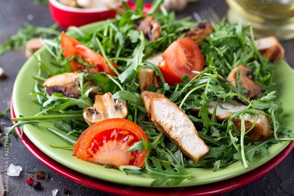 Close-up on a salad with chicken and tomato on green ceramic plate in a stone table. Healthy diet food concept, Close-up on a salad with chicken and tomato on green ceramic plate in a stone table. Healthy diet food concept,