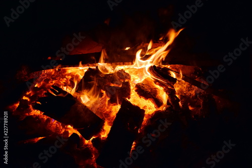 The fire burns,glowing charcoal.Dark background