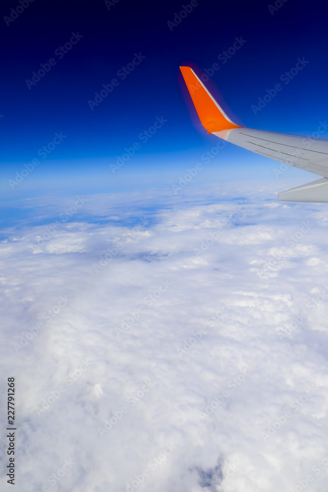 Obraz premium airplane wing over the blue cloud sky