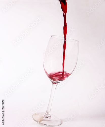 A glass of splashing pouring red wine