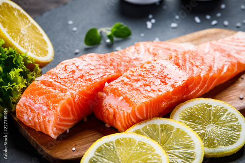 Canvas Print Fresh raw salmon fish served on black stone on wooden table