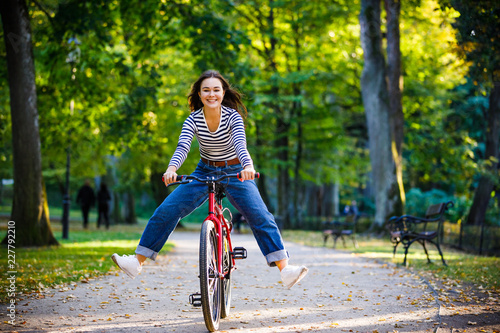 Fototapeta Naklejka Na Ścianę i Meble -  Urban biking - woman riding bike in city park