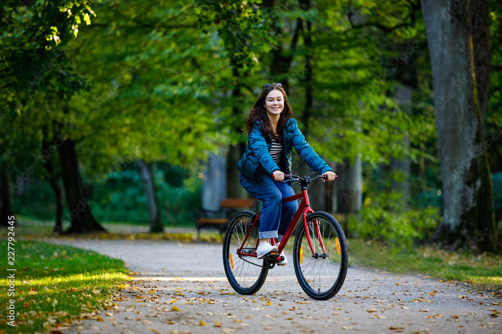 Urban biking - woman riding bike in city park