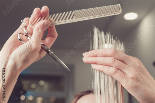 Hairdresser is cutting long hair in hair salon