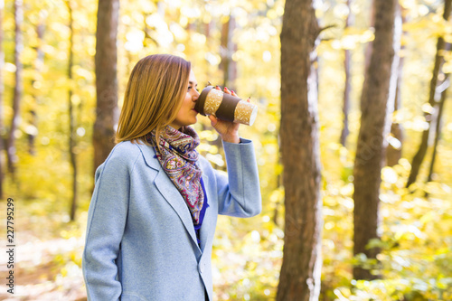 Fall, nature, people concept - young brunette woman drink coffee in autumn park © satura_