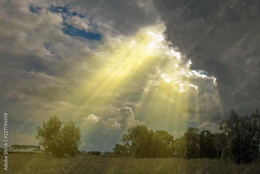 dramatic landscape sun rays breaking through storm clouds