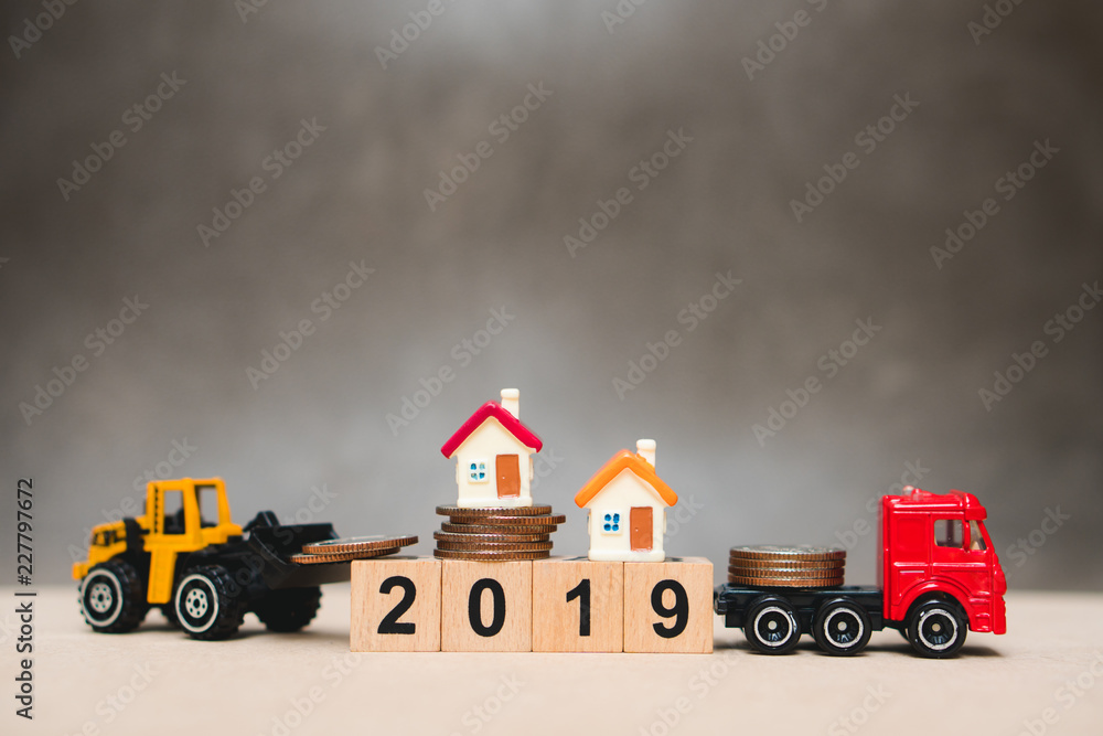 Miniature house on year 2019 wooden block with construction vehicle using as business and construction concept