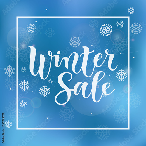 Modern calligraphy lettering of Winter Sale in white on blue background with frame and white snowflakes for advertising, flyer, poster, banner, shop, catalogue, hand bill