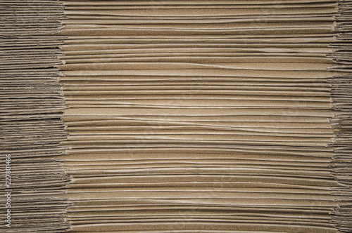 The texture of the cardboard. Pale brown cardboard packaging. Side view. Gray and brown background.