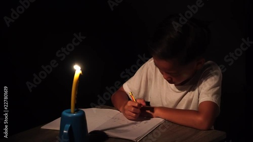 4k young Asian poor boy do homework under a candle light without electricity.