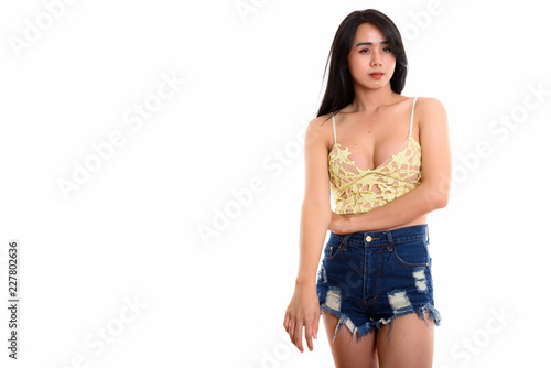 Studio shot of young Asian transgender woman posing while thinki photo