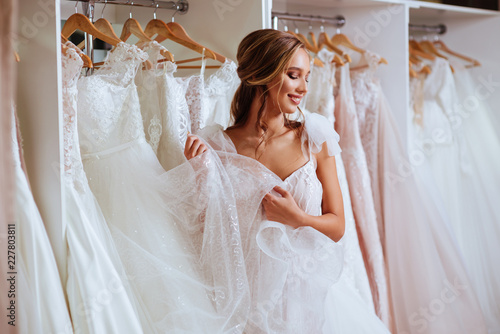 Beautiful bride is trying on an elegant wedding dress