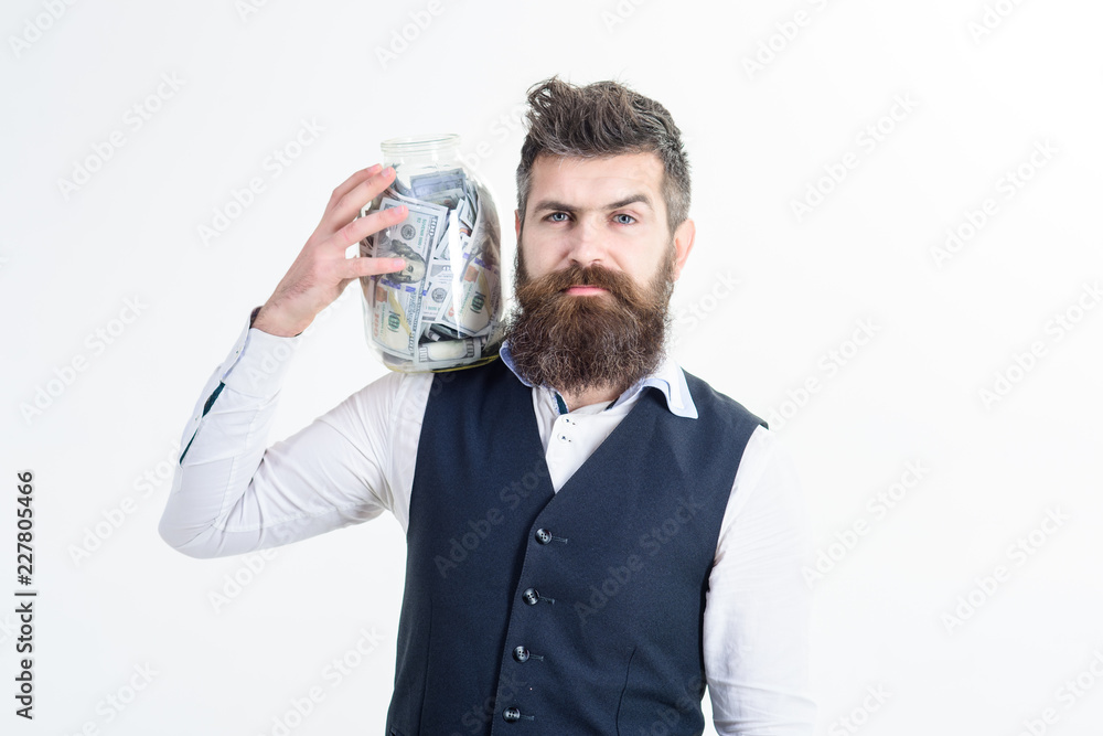 Business success, finance. Rich man. Wealth. Serious man hold jar full of dollars. Money economy concept. Bearded man with jar full of money on shoulder. Investment, finance, currency, banking concept Business success, finance. Rich man. Wealth. Serious man hold jar full of dollars. Money economy concept. Bearded man with jar full of money on shoulder. Investment, finance, currency, banking concept