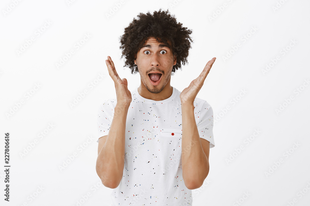 Man describing feelings to friends after amazing match he attended. Portrait of impressed and amazed good-looking hispanic male with moustache and curly hair, gesturing palms and dropping jaw Man describing feelings to friends after amazing match he attended. Portrait of impressed and amazed good-looking hispanic male with moustache and curly hair, gesturing palms and dropping jaw
