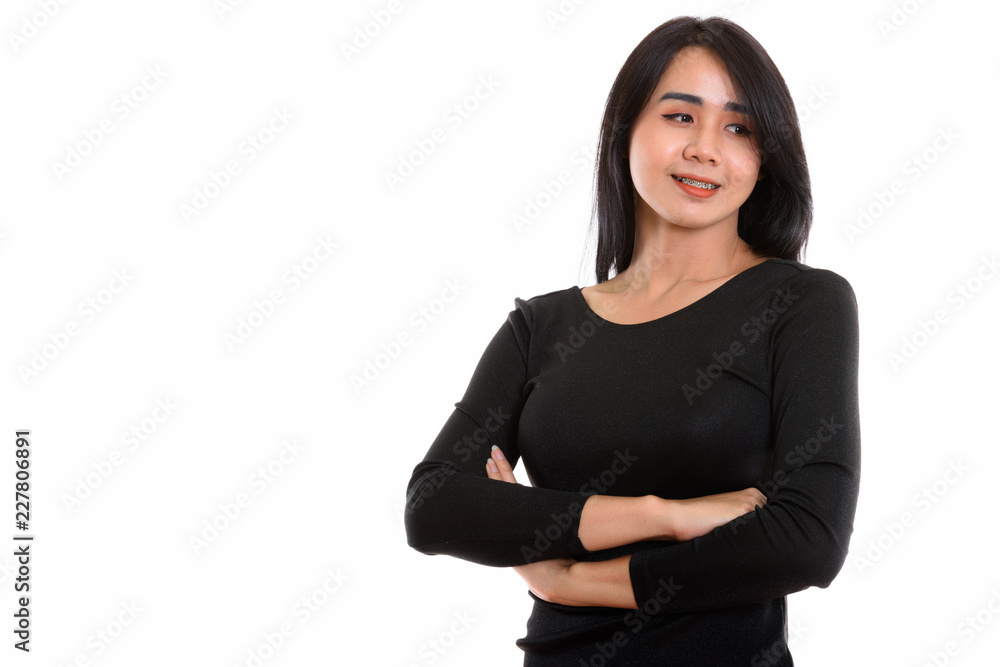 Studio shot of young happy Asian transgender woman smiling while Studio shot of young happy Asian transgender woman smiling while