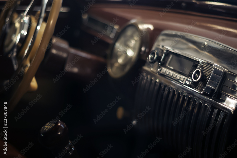 Blurred cold background - a fragment of the interior of a vintage car, focus on the handle of the radio