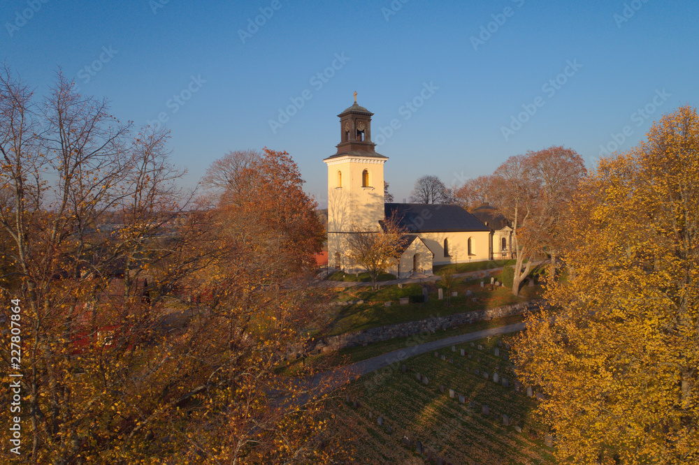 Turinge kyrka omgiven av höstens färger.
