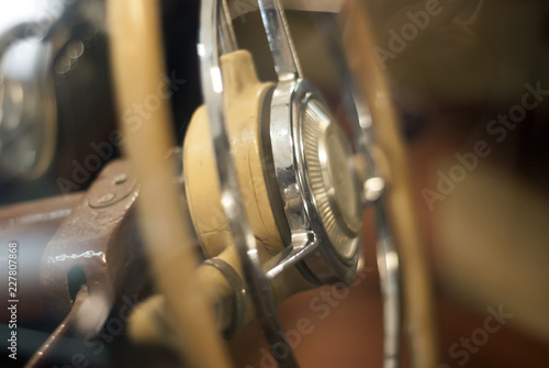 Blurred warm background - a fragment of the interior of a vintage car, focus on steering wheel detail © Evgeny