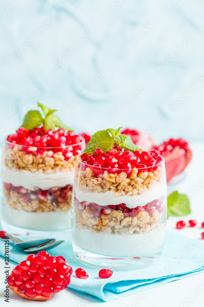 Pomegranate parfait - sweet organic layered dessert with granola flakes, yogurt and ripe fruit seeds. Pomegranate parfait - sweet organic layered dessert with granola flakes, yogurt and ripe fruit seeds.