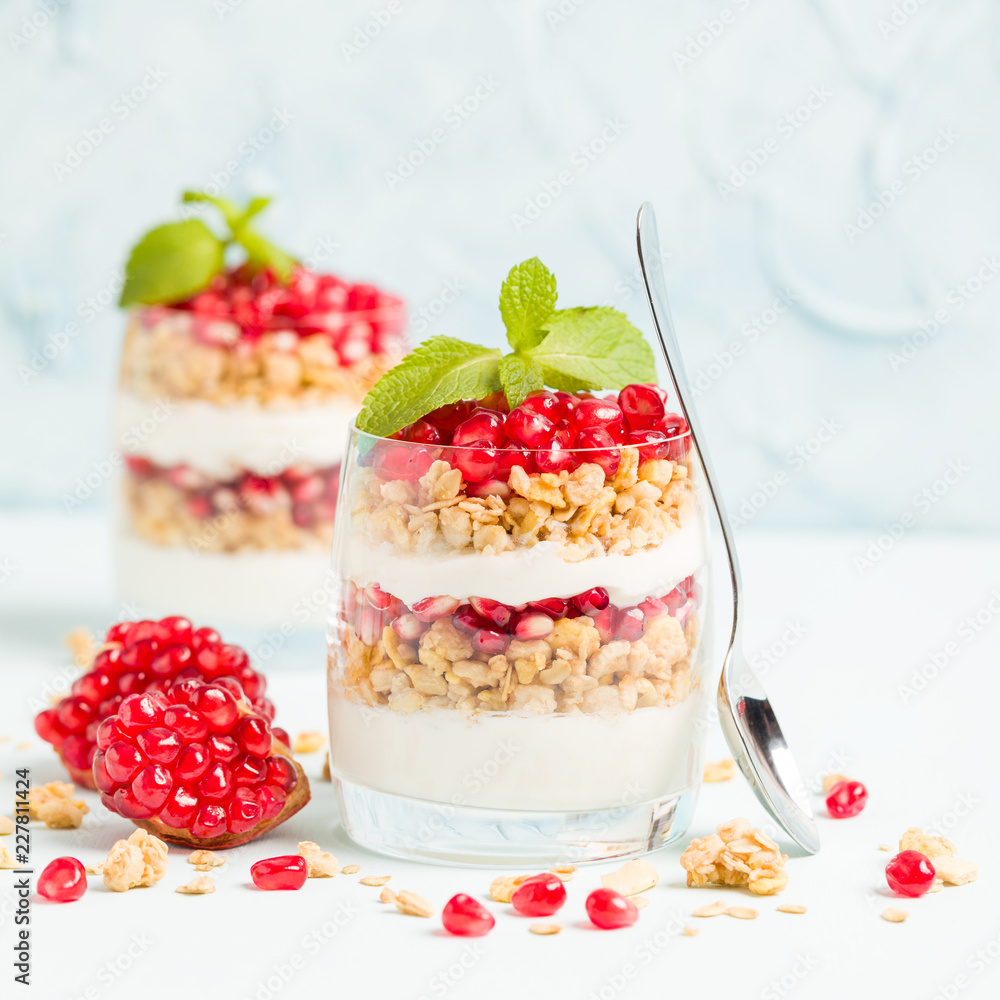 Pomegranate parfait - sweet organic layered dessert with granola flakes, yogurt and red ripe fruit seeds. Pomegranate parfait - sweet organic layered dessert with granola flakes, yogurt and red ripe fruit seeds.