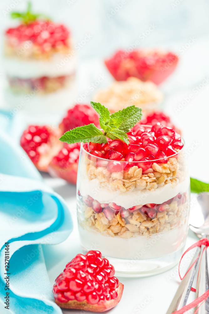 Pomegranate parfait - sweet organic layered dessert with granola flakes, yogurt and red ripe fruit seeds. Pomegranate parfait - sweet organic layered dessert with granola flakes, yogurt and red ripe fruit seeds.
