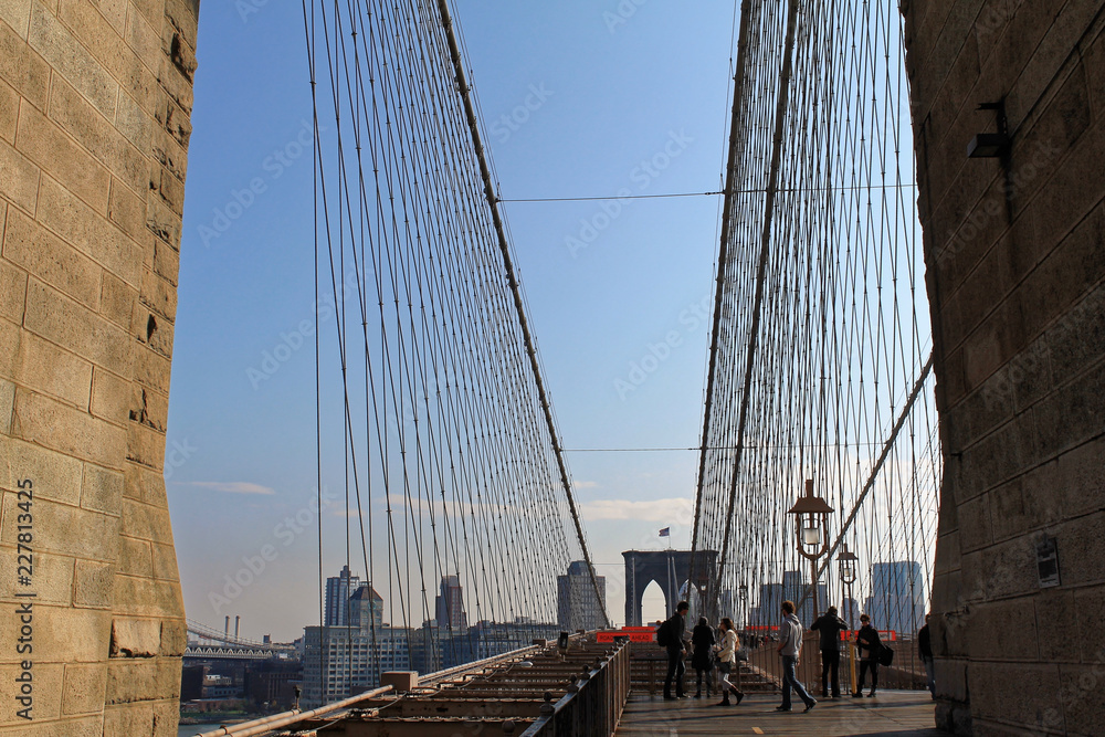 Obraz premium New York, USA - November 22, 2010: Spectacular views of the Brooklyn Bridge with all its characteristic metal wires and the pedestrian walkway
