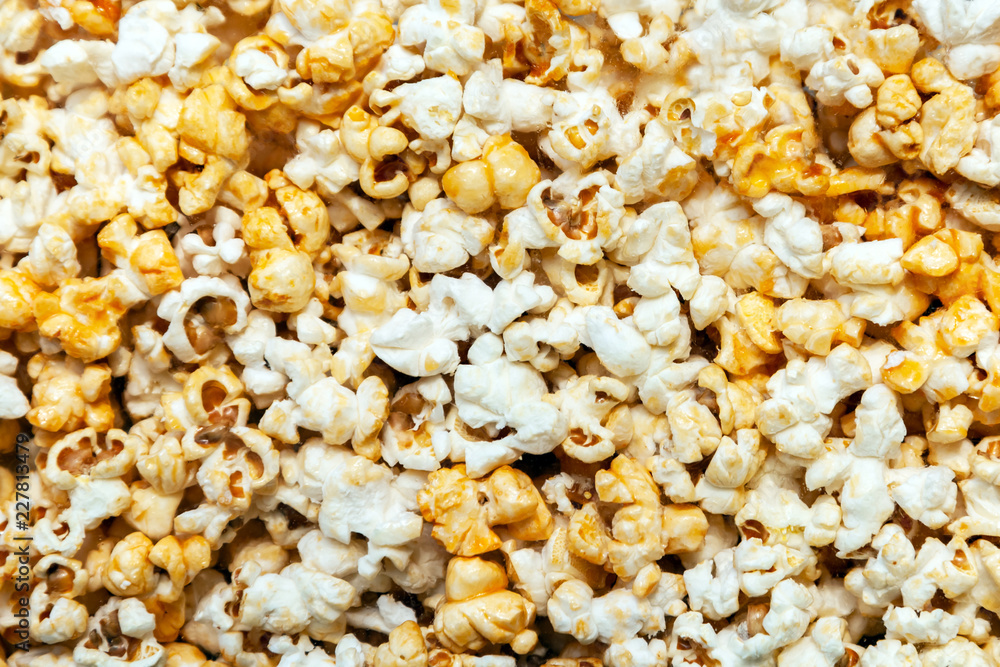 Popcorn texture background. A pile of pop corn behind the glass Popcorn texture background. A pile of pop corn behind the glass