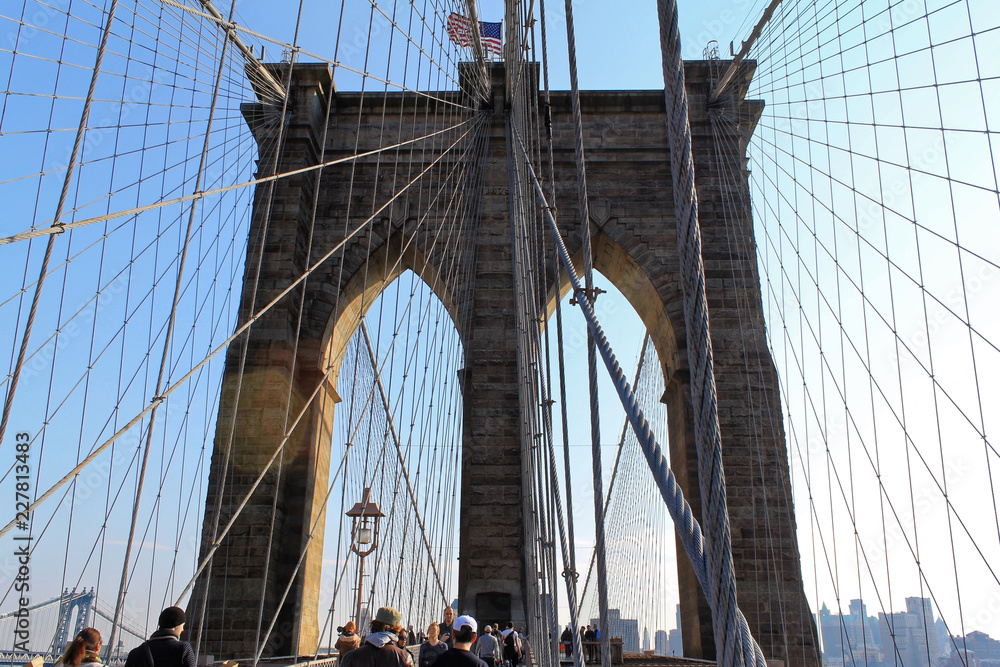 Obraz premium New York, USA - November 22, 2010: Spectacular views of the Brooklyn Bridge with all its characteristic metal wires and the pedestrian walkway