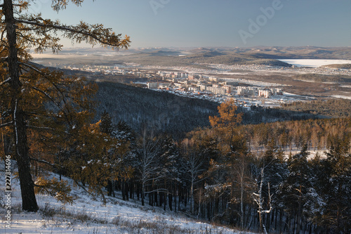 Winter landscape from the top of the mountain. The city is surrounded by forest and mountains.