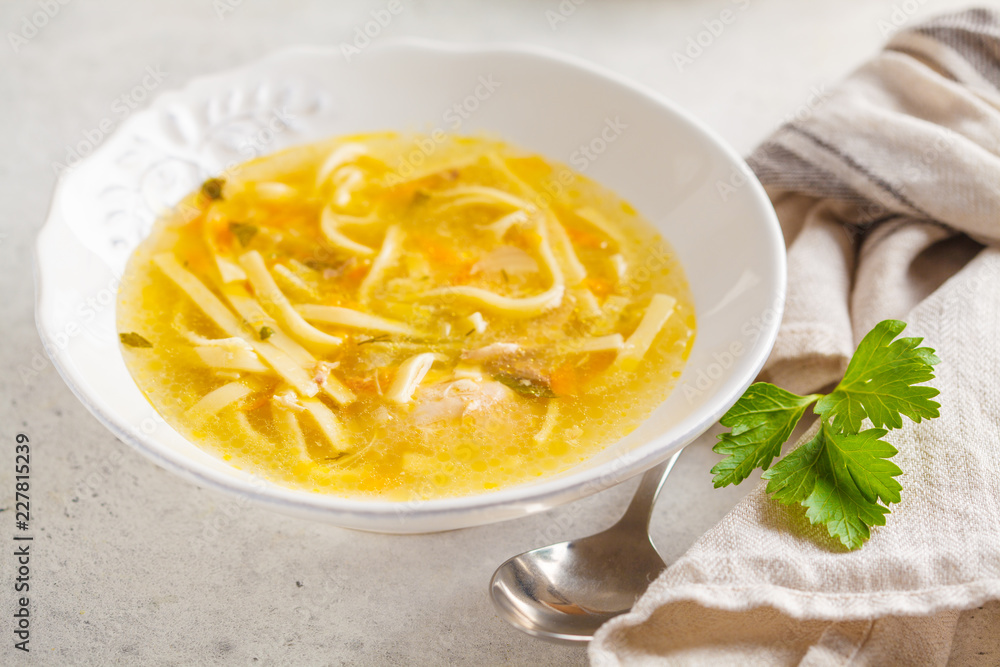 Homemade chicken noodle soup in a white plate, white background. Homemade chicken noodle soup in a white plate, white background.