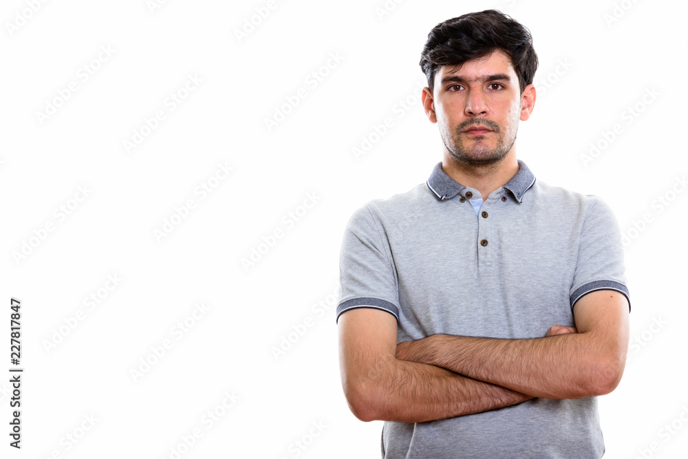 Studio shot of young Persian man with arms crossed Studio shot of young Persian man with arms crossed