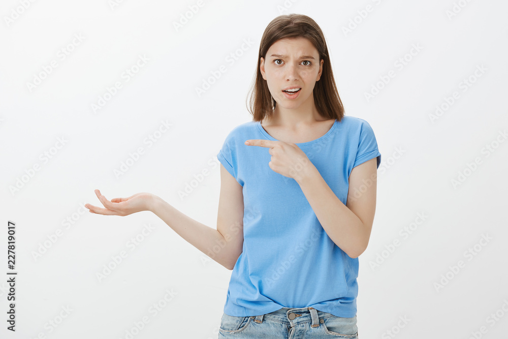 You really talking about this crap. Unimpressed snobbish woman in casual outfit, pointing left with forefinger and raising palm in clueless gesture, being uninterested and disappointed over grey wall You really talking about this crap. Unimpressed snobbish woman in casual outfit, pointing left with forefinger and raising palm in clueless gesture, being uninterested and disappointed over grey wall