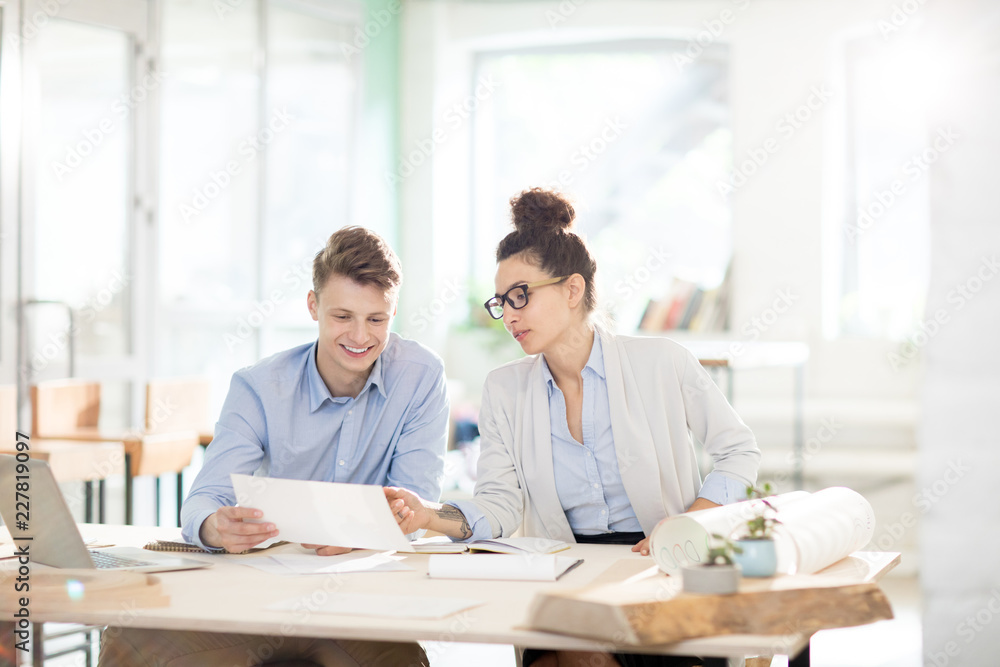 Confident female expert pointing at data on paper while discussing it with colleague at working meeting Confident female expert pointing at data on paper while discussing it with colleague at working meeting