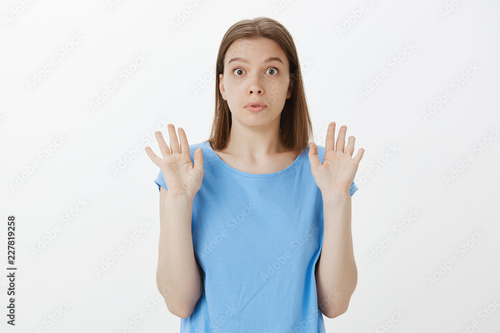 It was not me. Portrait of shocked innocent cute girl with fair hair, raising palms in surrender and staring with popped eyes at camera, being unaware and uninvolved, having no idea what happened It was not me. Portrait of shocked innocent cute girl with fair hair, raising palms in surrender and staring with popped eyes at camera, being unaware and uninvolved, having no idea what happened