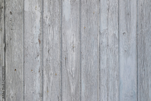 Aged wooden surface of vertical planks with cracked white paint, texture for backround